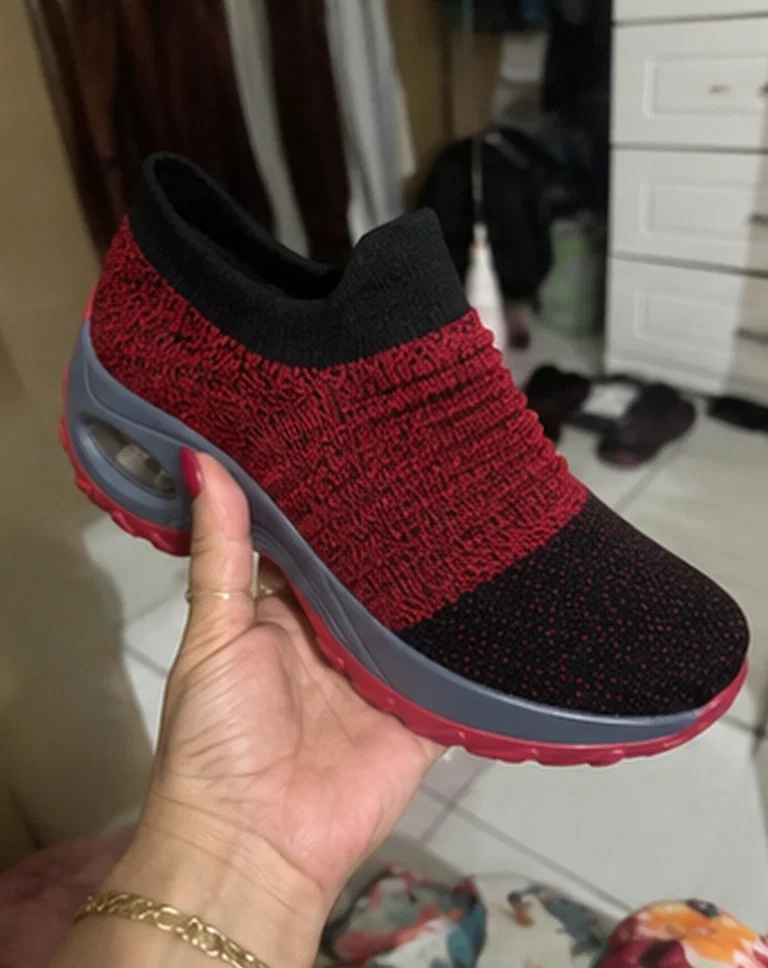 Cliente segurando o tênis vermelho e preto